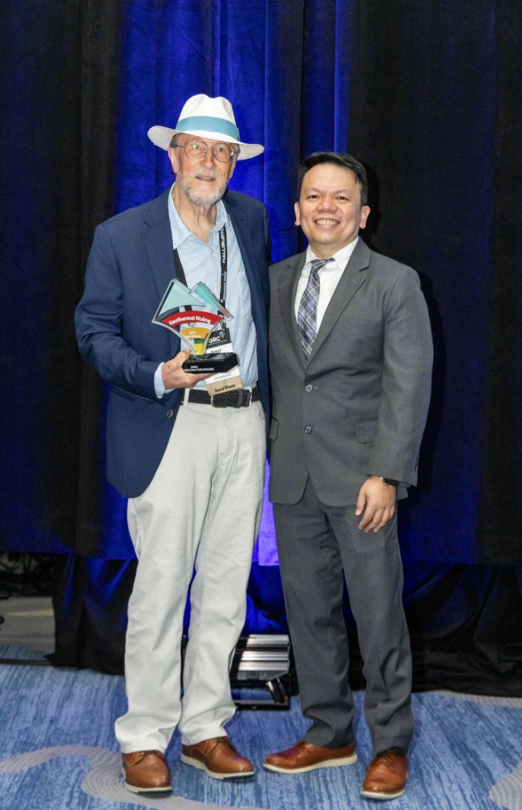 Peter Malin holding the award trophy beside Jericho Reyes